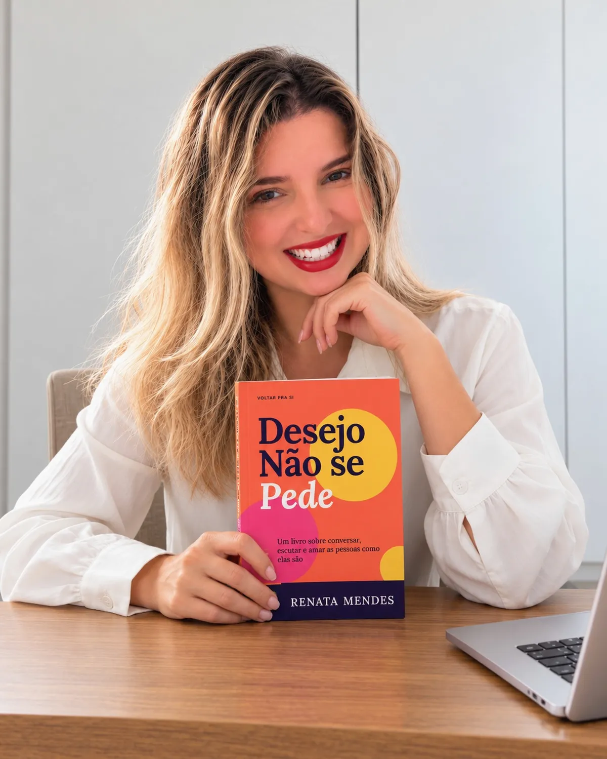 Renata à mesa segurando Desejo Não se Pede